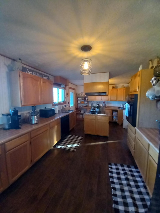 kitchen with light brown cabinetry, dark wood-type flooring, black appliances, hanging light fixtures, and tile counters