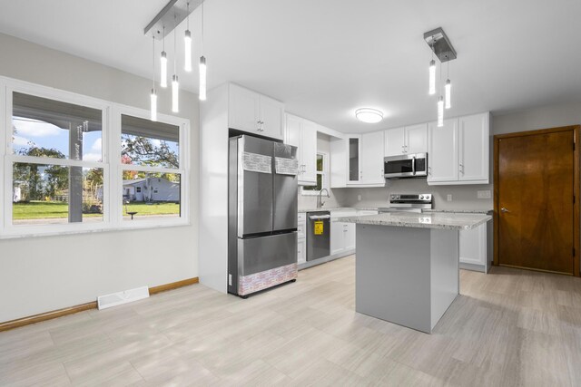 5608 Cardinal Dr, Orient, OH 43146 - kitchen featuring stainless steel appliances, white cabinetry, light stone counters, a center island, and pendant lighting