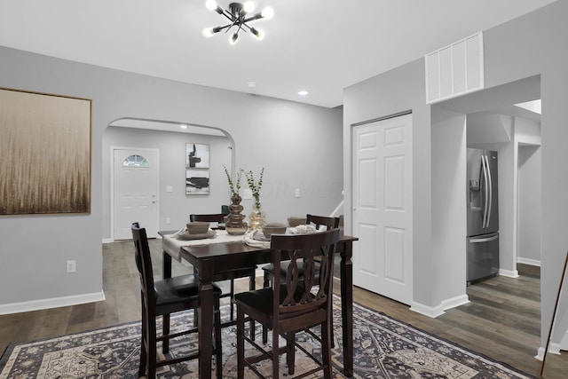 dining room with dark hardwood / wood-style flooring and a chandelier