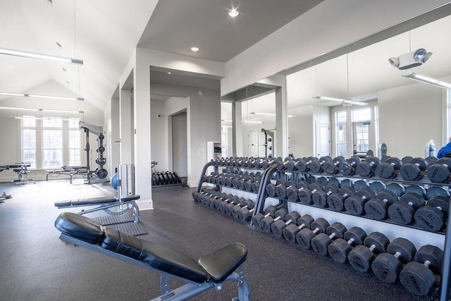 gym featuring ceiling fan, a healthy amount of sunlight, and vaulted ceiling