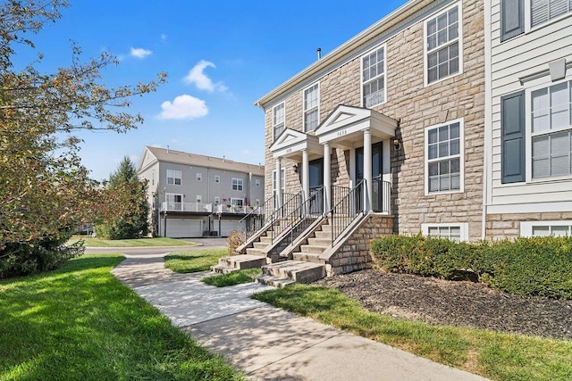 townhome / multi-family property featuring a front lawn