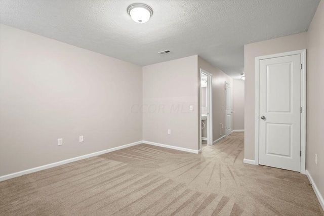 carpeted empty room featuring a textured ceiling