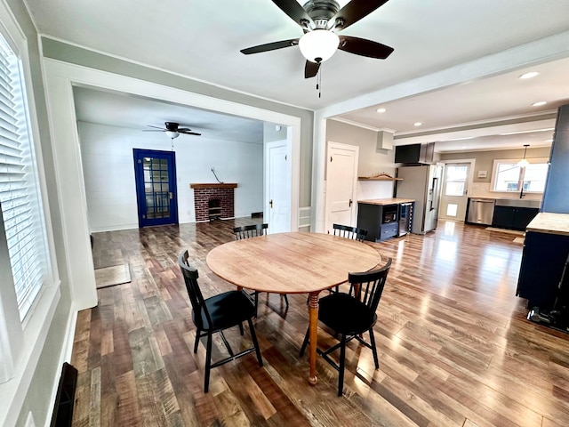 dining area featuring a fireplace, dark hardwood / wood-style floors, and ceiling fan