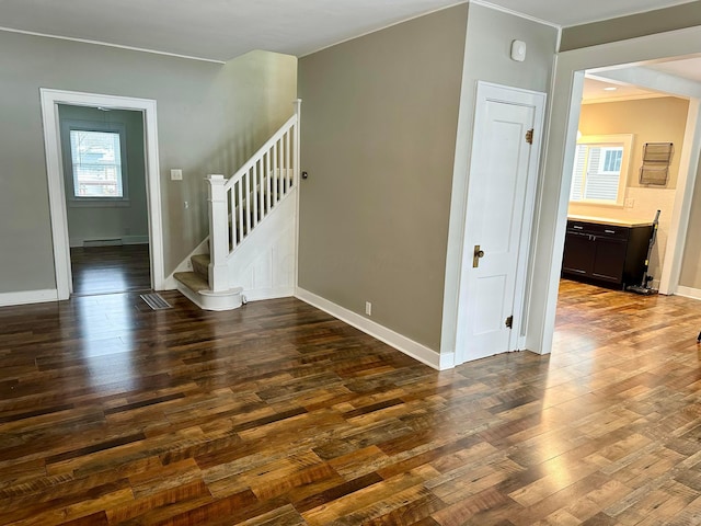 empty room featuring dark hardwood / wood-style floors and a baseboard heating unit