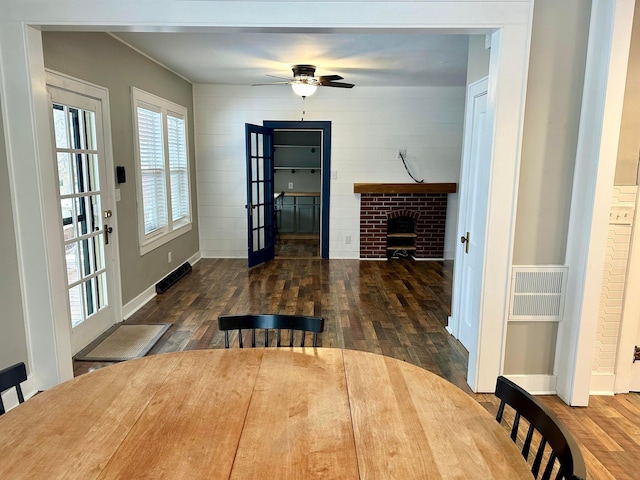 dining room featuring a fireplace, french doors, dark hardwood / wood-style floors, and ceiling fan