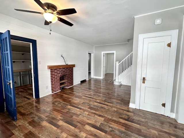 unfurnished living room featuring ceiling fan, a fireplace, and dark hardwood / wood-style floors