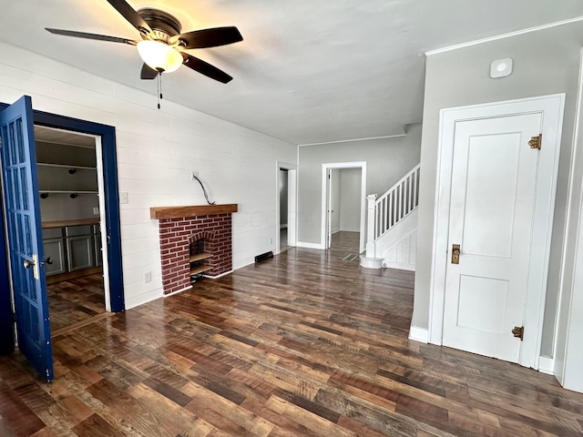 unfurnished living room featuring dark hardwood / wood-style floors, ceiling fan, and a fireplace