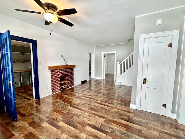 unfurnished living room featuring dark hardwood / wood-style flooring, ceiling fan, and a fireplace