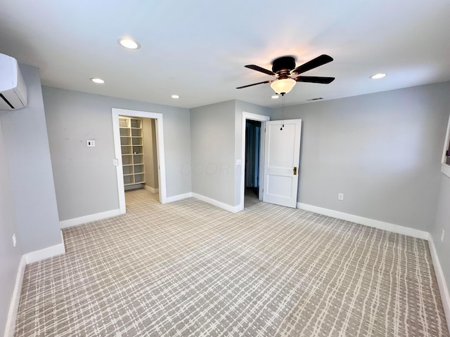 spare room featuring a wall mounted air conditioner and ceiling fan