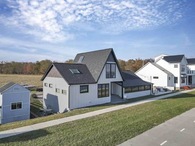 view of front of house with a sunroom and a front lawn