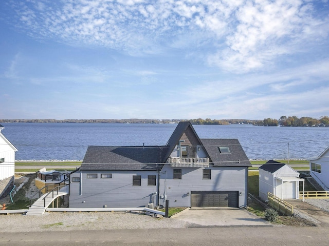 view of front of house with a balcony, a water view, and a garage