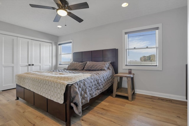 bedroom with ceiling fan, a closet, and light hardwood / wood-style flooring