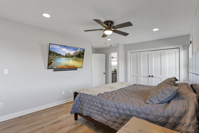 bedroom with a textured ceiling, a closet, hardwood / wood-style flooring, and ceiling fan