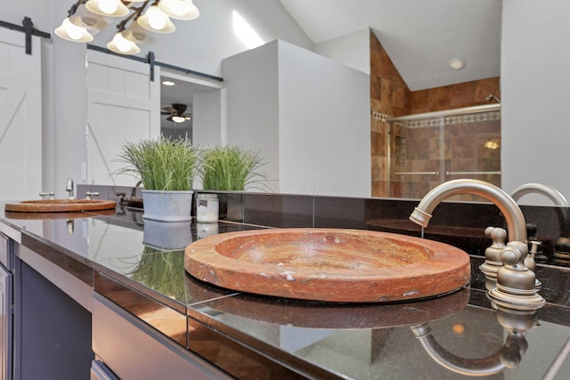 bathroom with ceiling fan, an enclosed shower, lofted ceiling, and vanity