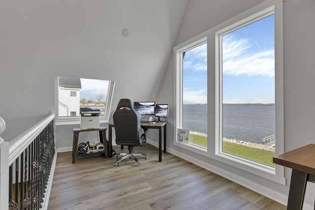 office area featuring light wood-type flooring, plenty of natural light, and lofted ceiling