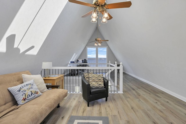 living area featuring ceiling fan, lofted ceiling, and light wood-type flooring