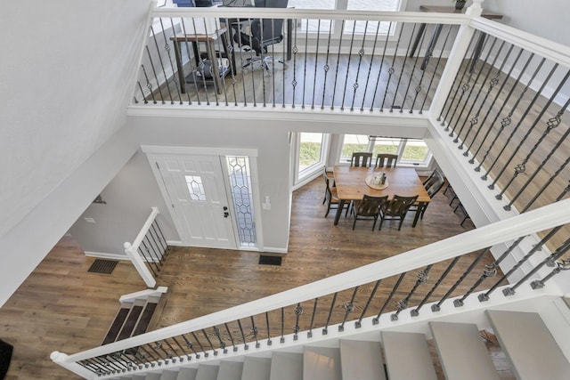 entryway with dark hardwood / wood-style floors and a towering ceiling