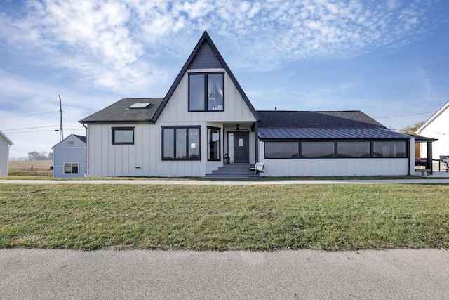 modern farmhouse style home with a sunroom and a front yard