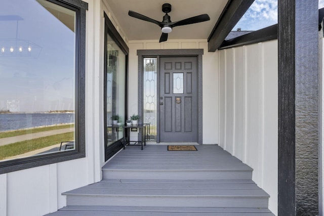 property entrance with ceiling fan and a water view