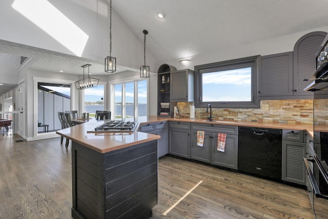 kitchen featuring a textured ceiling, backsplash, black dishwasher, and a wealth of natural light