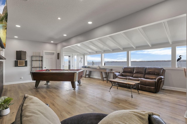 rec room with billiards, lofted ceiling with beams, a textured ceiling, and light wood-type flooring