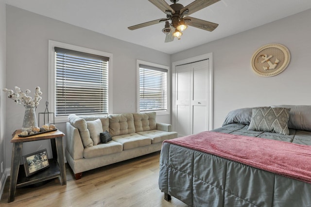 bedroom with ceiling fan, light hardwood / wood-style floors, and a closet