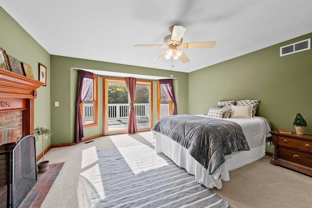 carpeted bedroom featuring a fireplace, a textured ceiling, access to outside, and ceiling fan