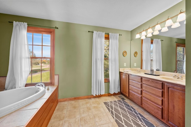 bathroom featuring tile patterned flooring, vanity, a bath, and a wealth of natural light