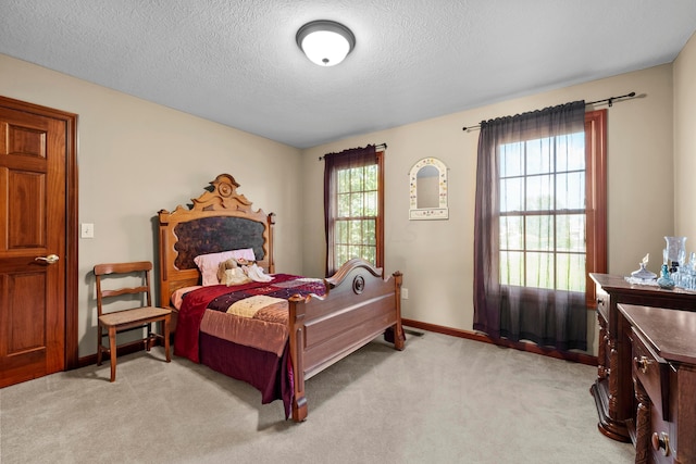 carpeted bedroom featuring a textured ceiling and multiple windows