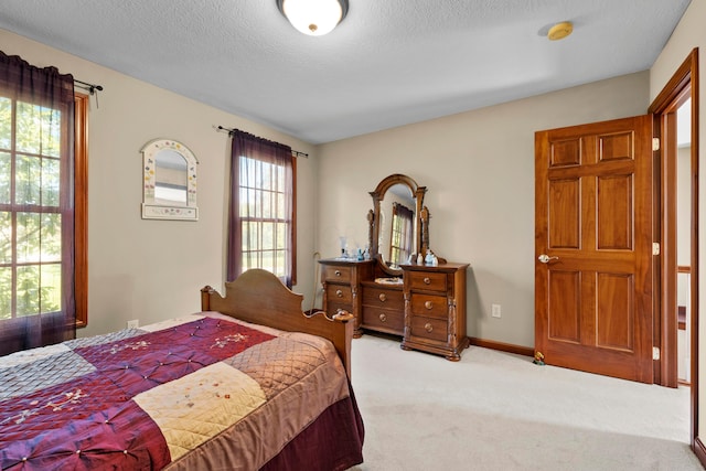 carpeted bedroom featuring a textured ceiling and multiple windows