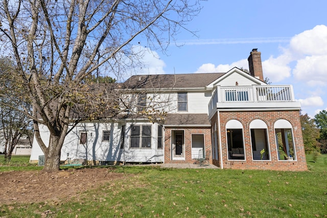 view of front facade featuring a balcony and a front lawn