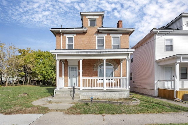 view of front of property with a front yard and covered porch