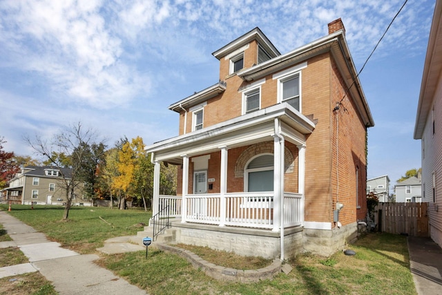 view of front of property with covered porch and a front yard