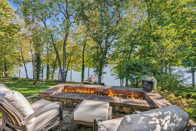 view of patio with a fire pit and a water view