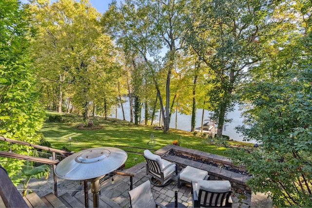 view of home's community featuring a water view, an outdoor fire pit, a patio, and a yard