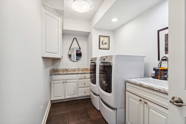 washroom featuring dark tile patterned floors, sink, independent washer and dryer, and cabinets