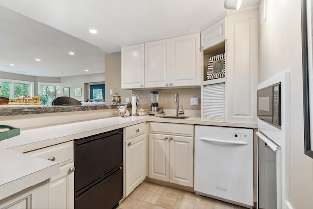 kitchen with white cabinets, dishwasher, sink, and black microwave