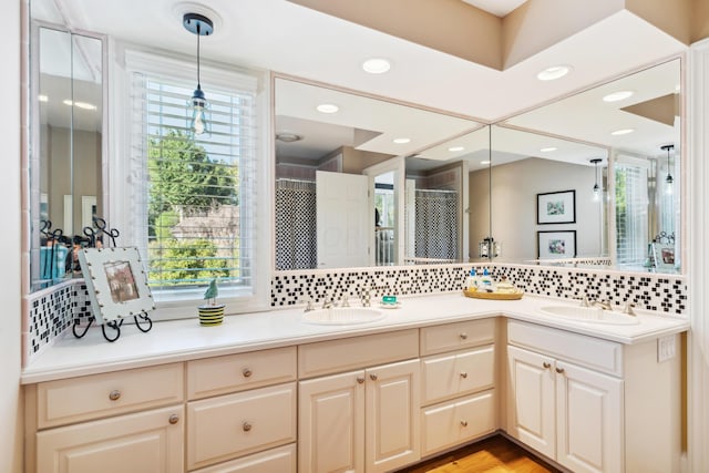 bathroom with backsplash, walk in shower, and vanity