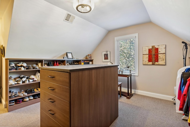 spacious closet with light carpet and vaulted ceiling