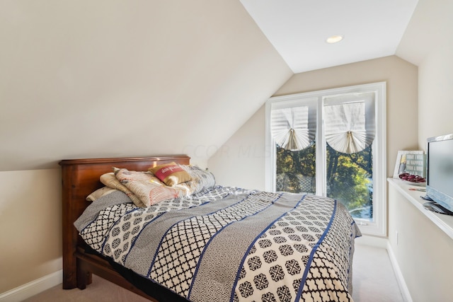 bedroom with lofted ceiling and light carpet