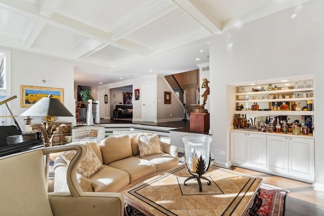 living room with beam ceiling, bar area, coffered ceiling, and light hardwood / wood-style flooring