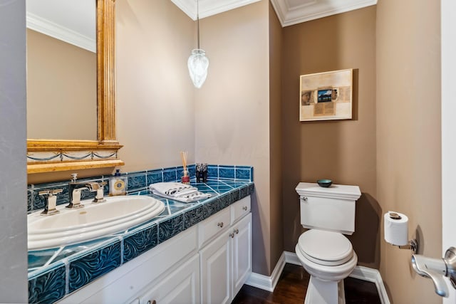 bathroom featuring toilet, vanity, and crown molding