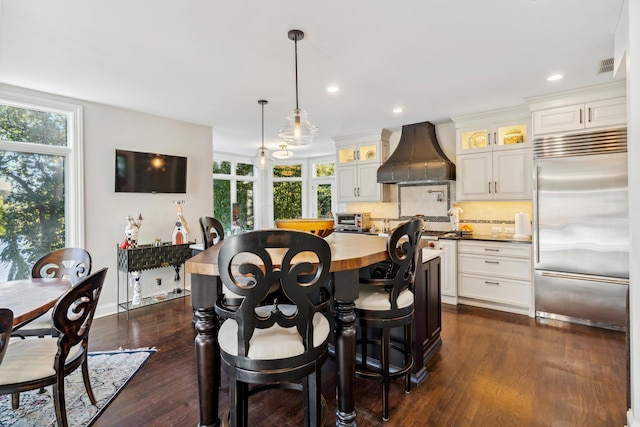 dining area with dark wood-type flooring and a healthy amount of sunlight