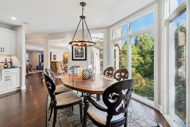 dining room featuring dark hardwood / wood-style floors, an inviting chandelier, and ornamental molding