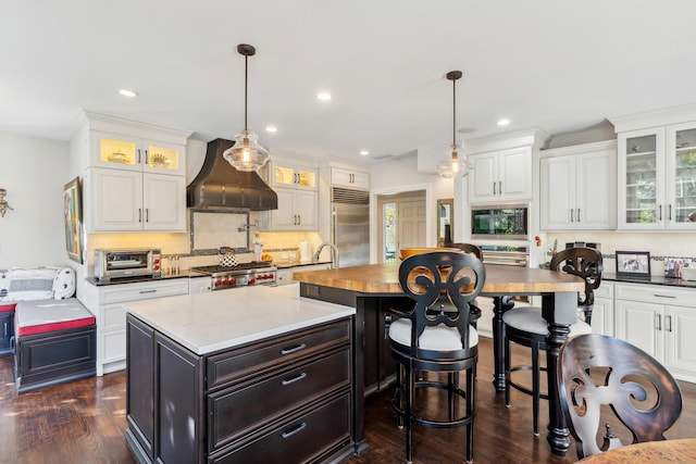 kitchen with tasteful backsplash, hanging light fixtures, and built in appliances