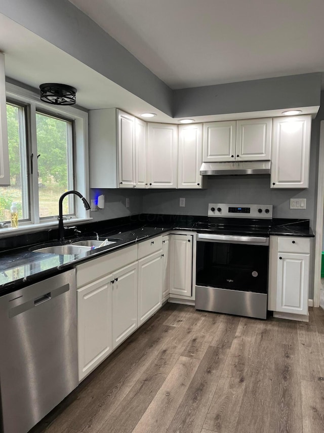 kitchen featuring sink, white cabinets, light hardwood / wood-style floors, and appliances with stainless steel finishes