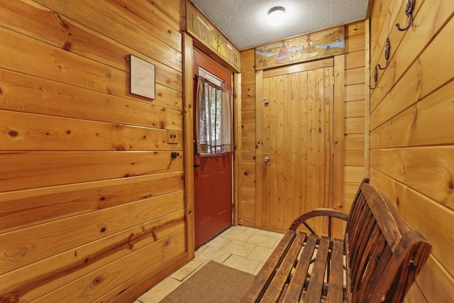 doorway featuring wood walls and a textured ceiling