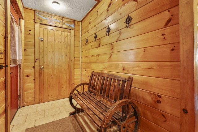 interior space featuring wood walls and a textured ceiling