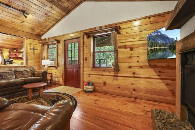 living room featuring wood walls, plenty of natural light, vaulted ceiling, and hardwood / wood-style flooring