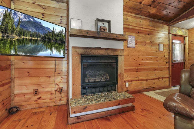 living room with wooden ceiling, wood walls, wood-type flooring, vaulted ceiling, and a fireplace